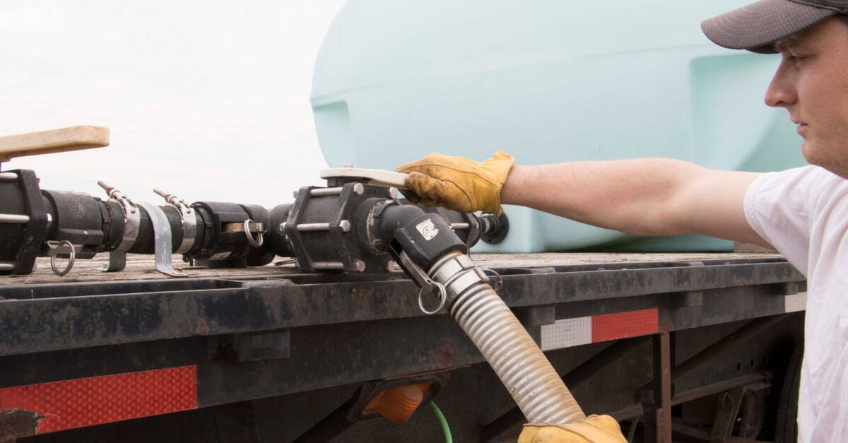 A farmer working with valve on agricultural equipment